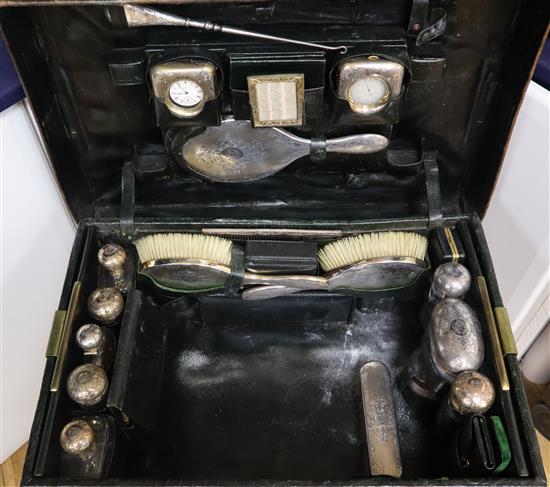 An Edwardian crocodile skin travelling toilet case, containing eighteen silver gilt/silver mounted implements, case 55cm.